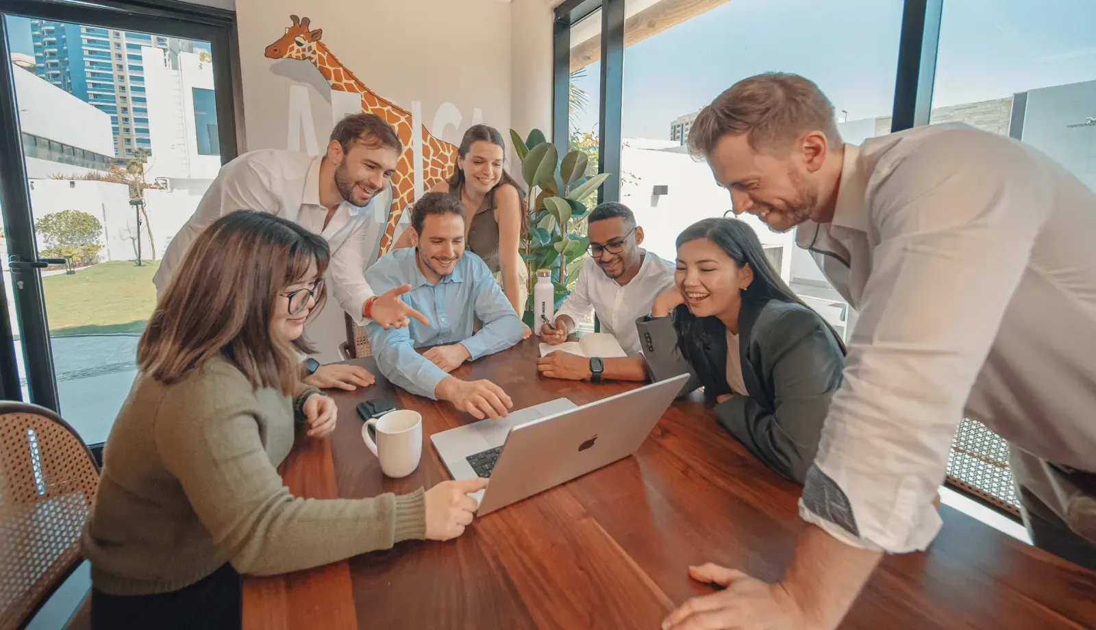 A team gathered around a laptop during a workshop at Nas House