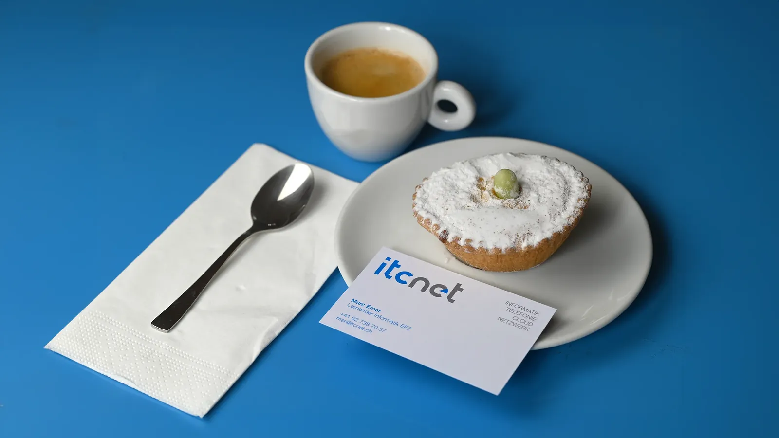 itcnet Visitenkarte neben Kaffee und Kuchen