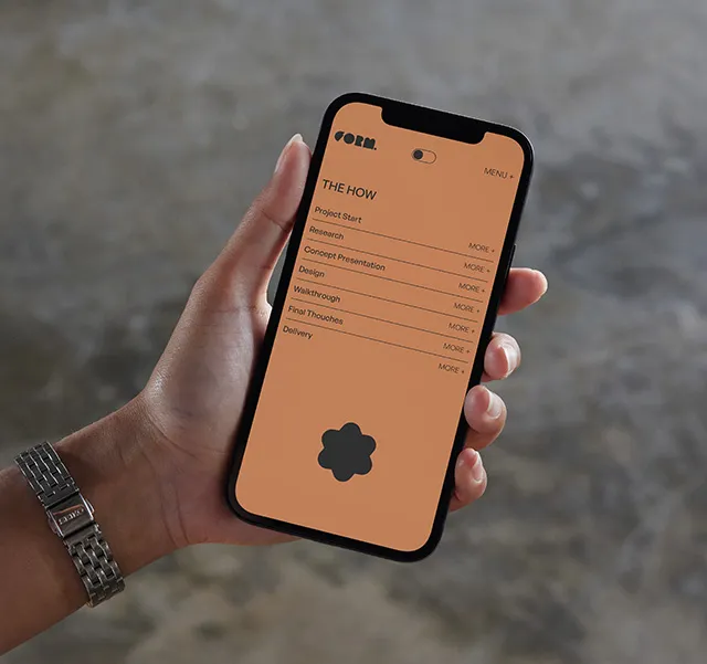 En kvinna som håller en telefon som visar Form Visuals hemsida.