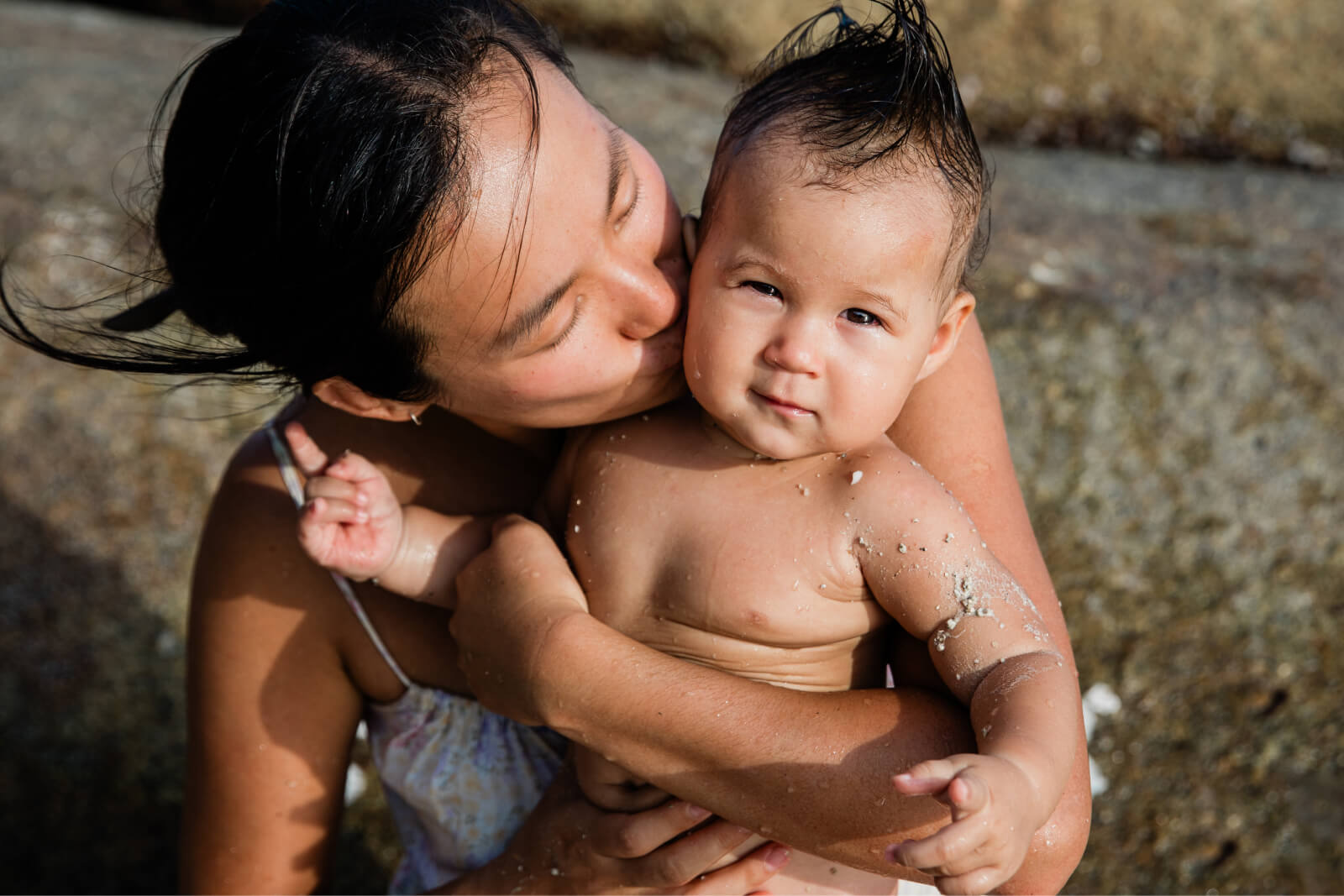 A Mother spends the afternoon at the beach with her baby son