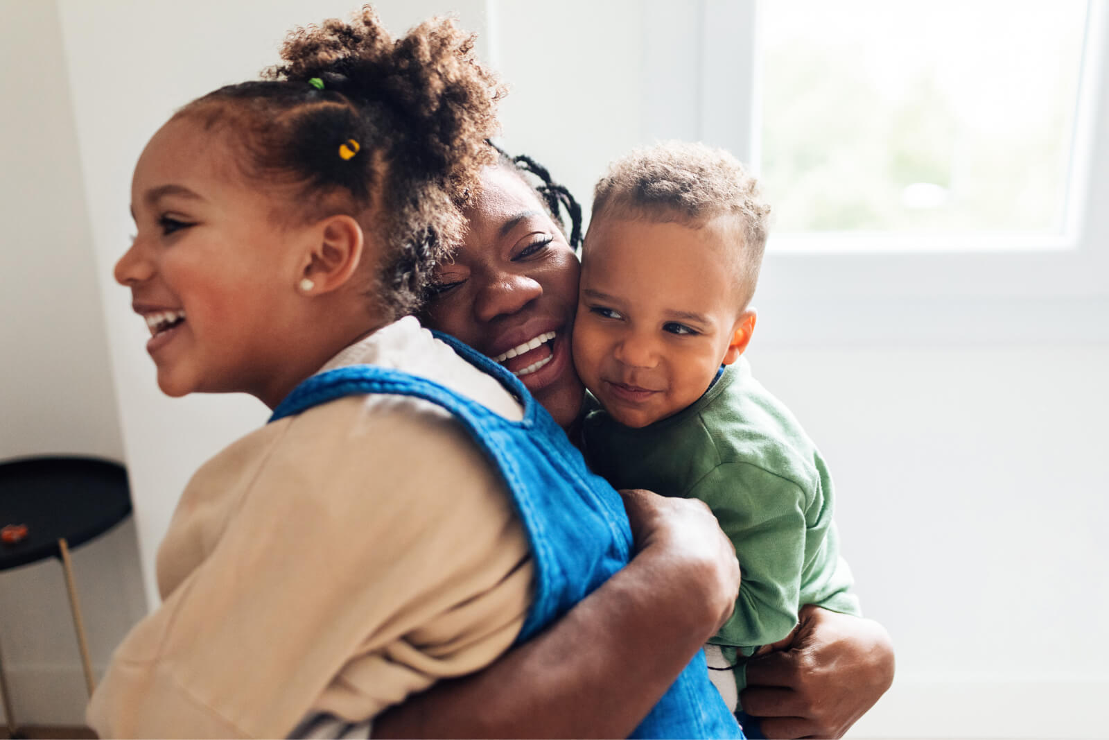 Woman hugging with her two cute children

