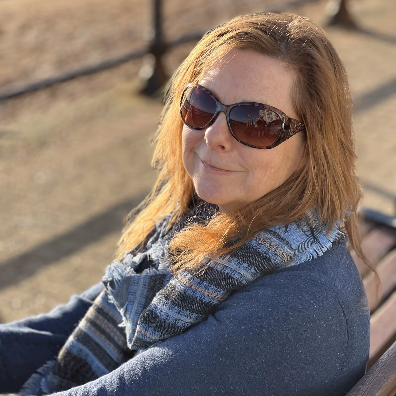 Lady sitting on a bench by the sea