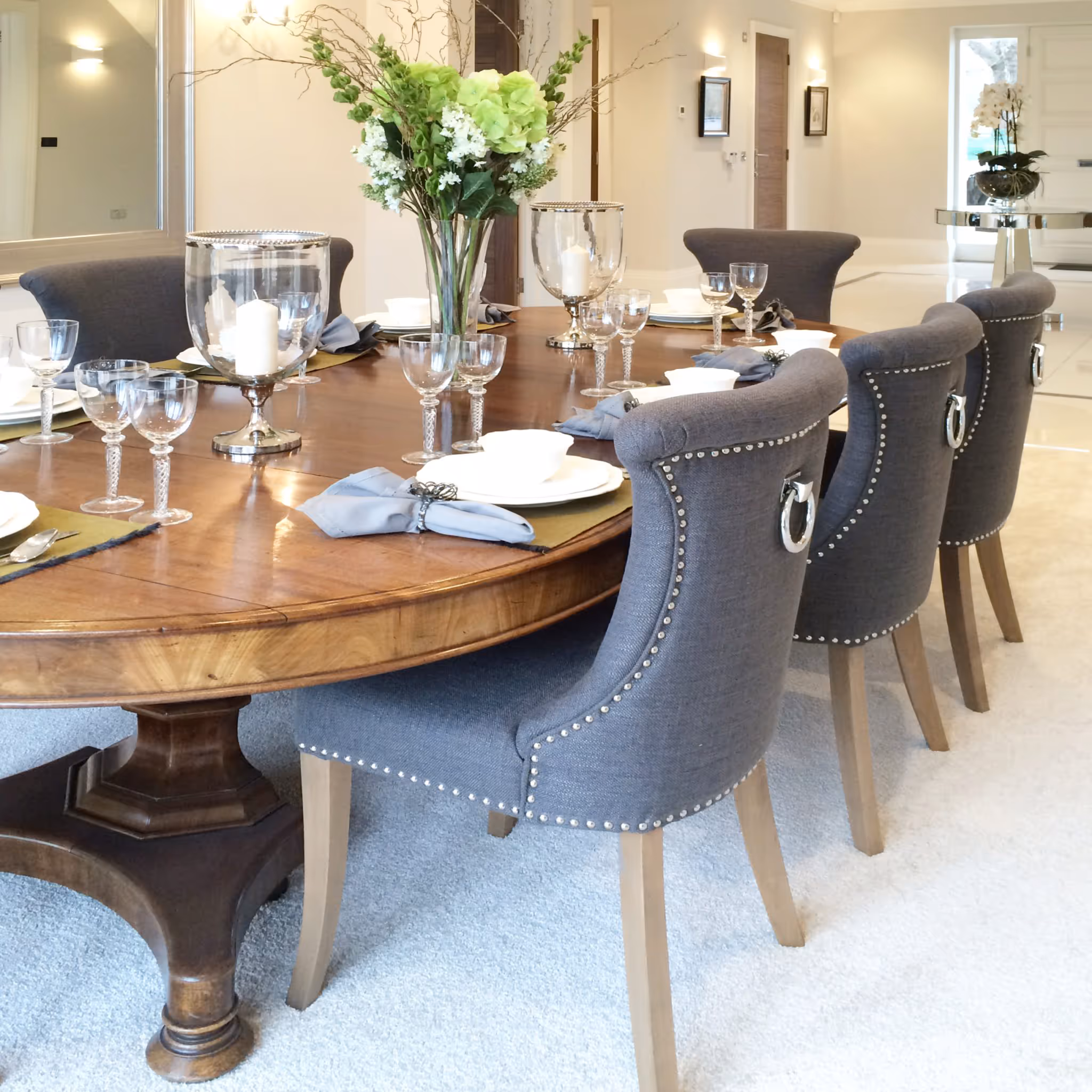 Antique dining table with grey upholstered chairs