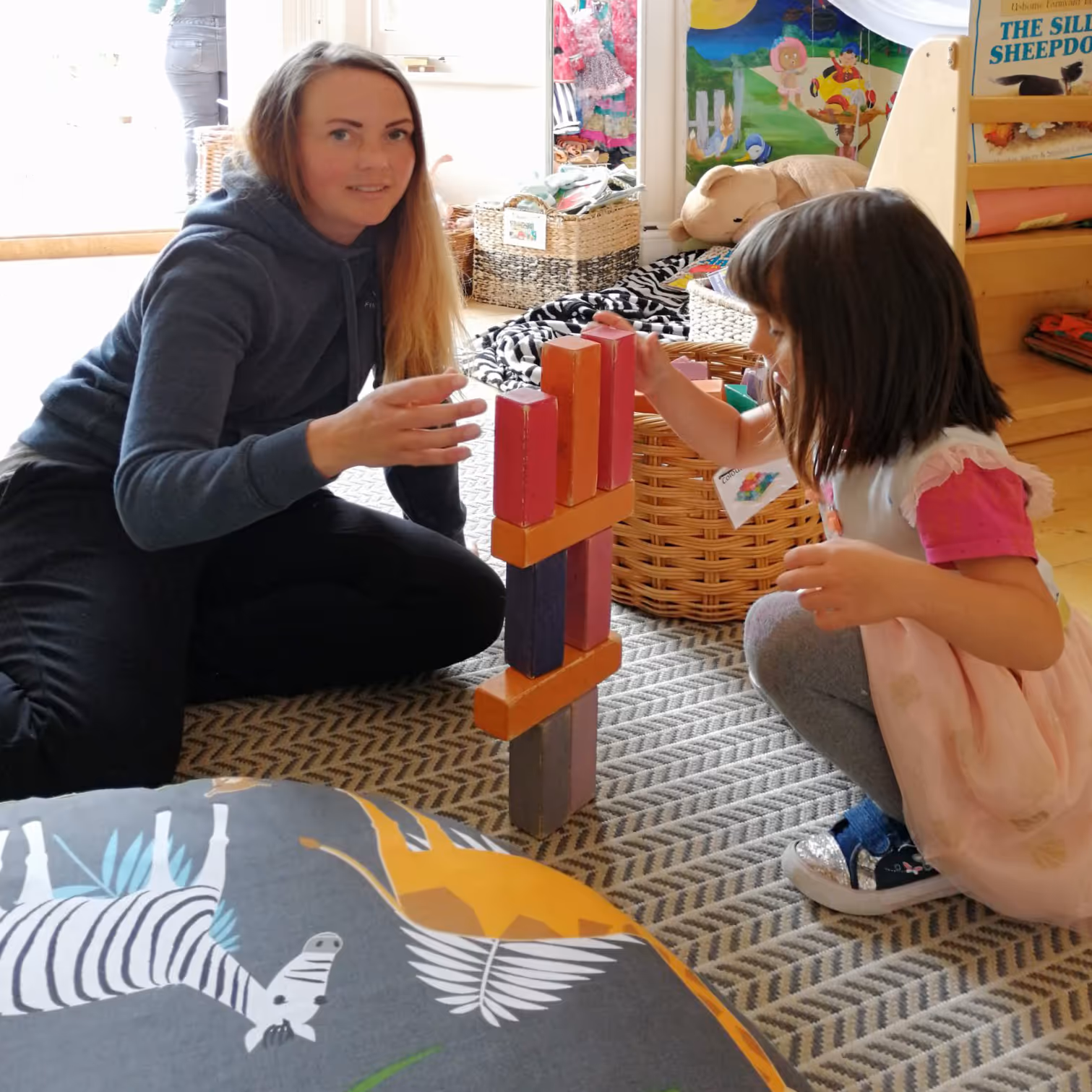 Teacher and child playing with toys
