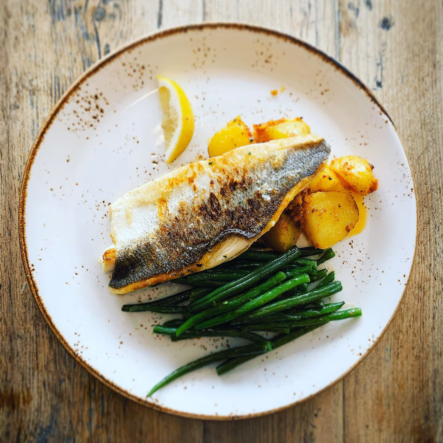Seabass fillet served with romanesco potatoes and french beans