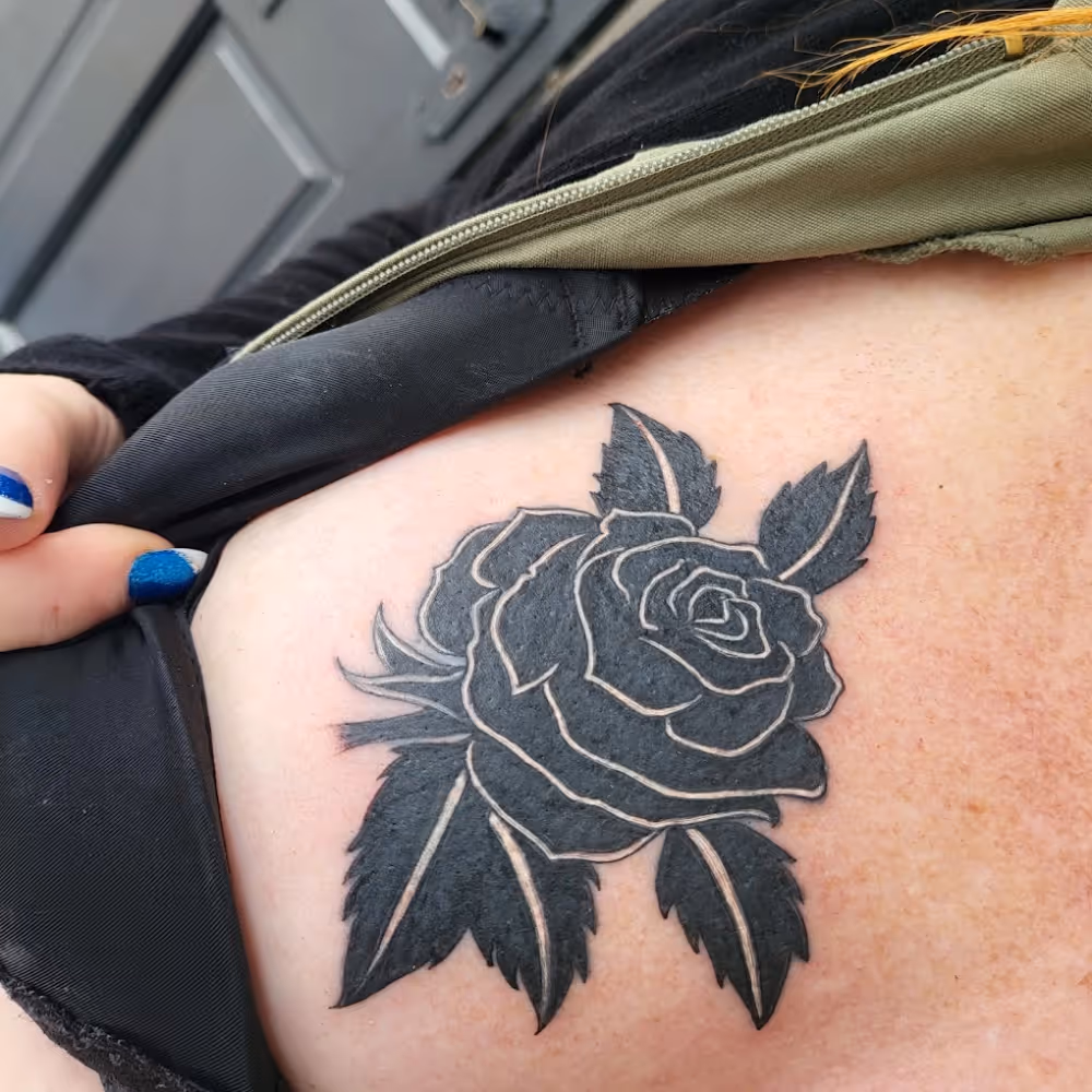 Tattoo of a rose with leaves