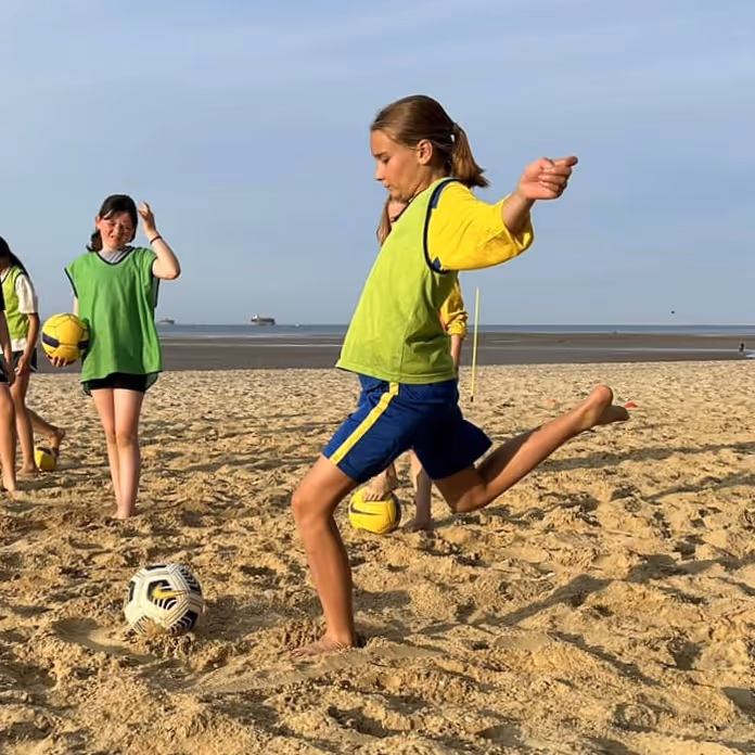 Kids playing football on the sand