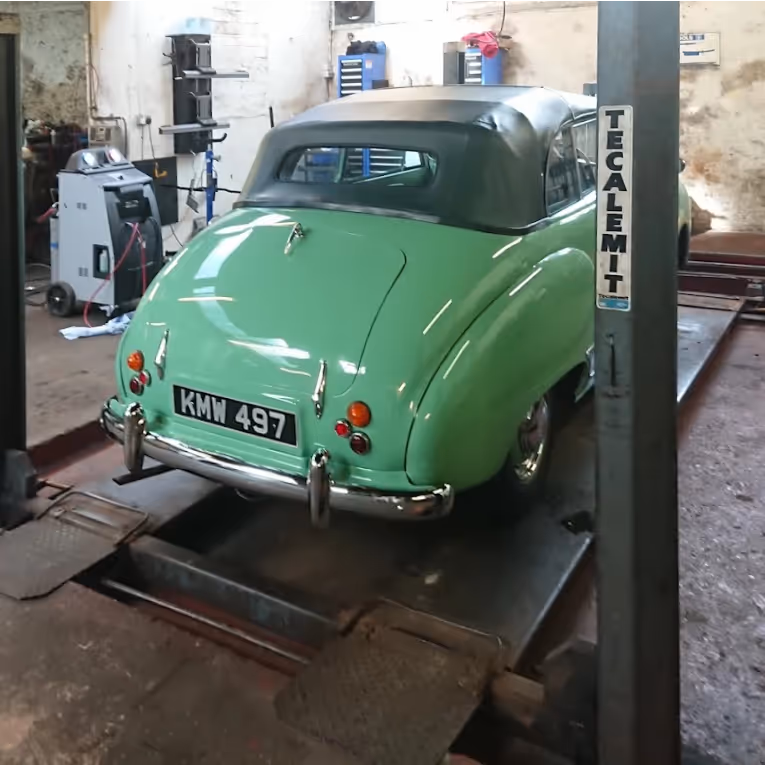 Old car being serviced in a garage