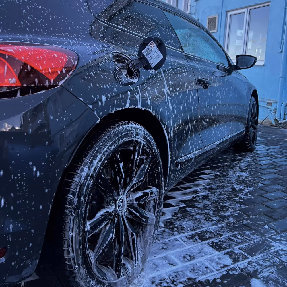 A black car covered in soap suds