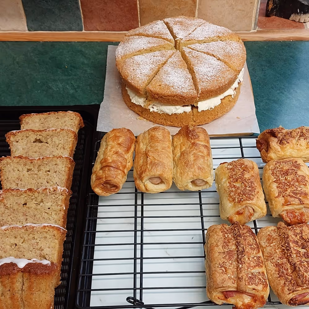 Cakes and sausage rolls on a cooling rack