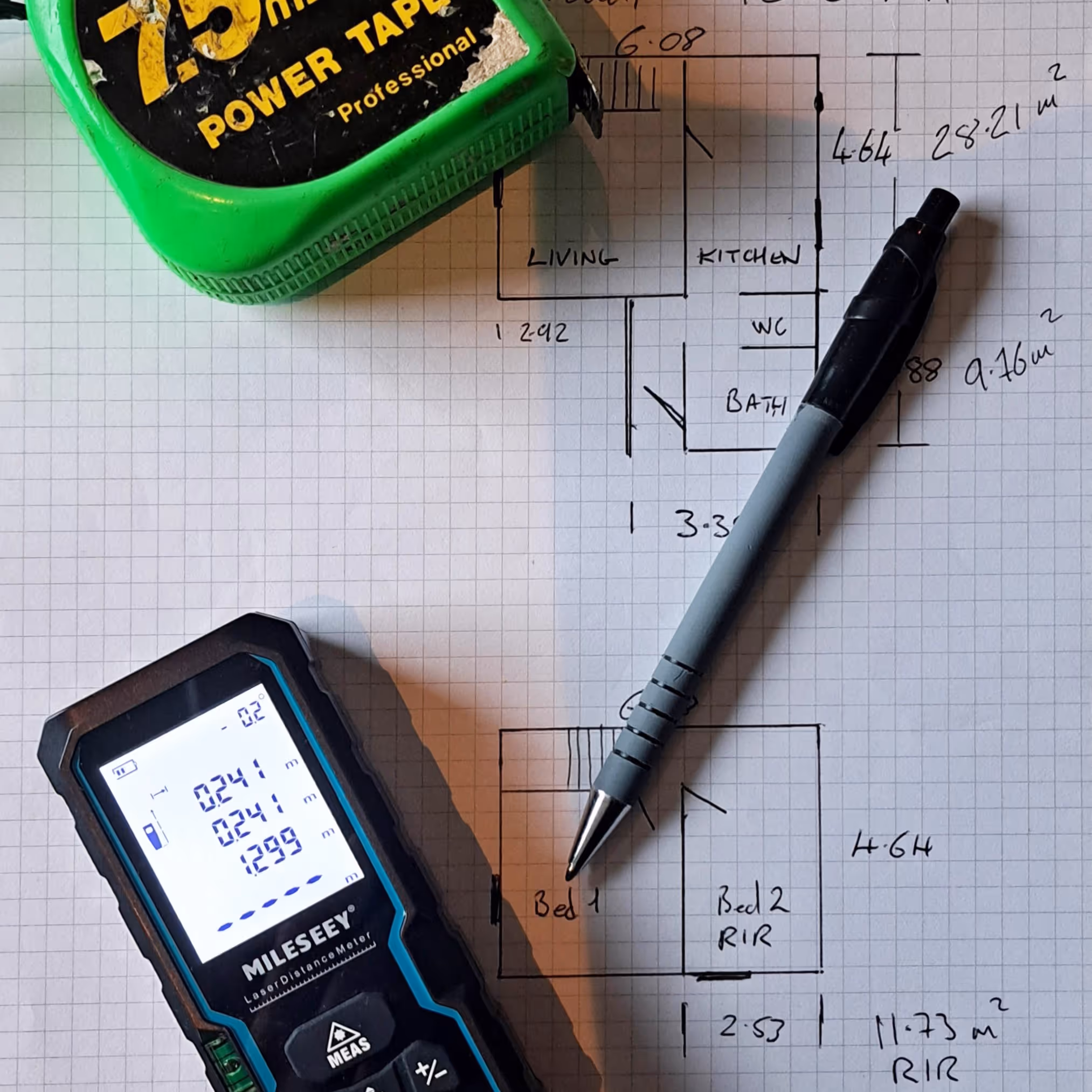 A houseplan with tape measure and pen