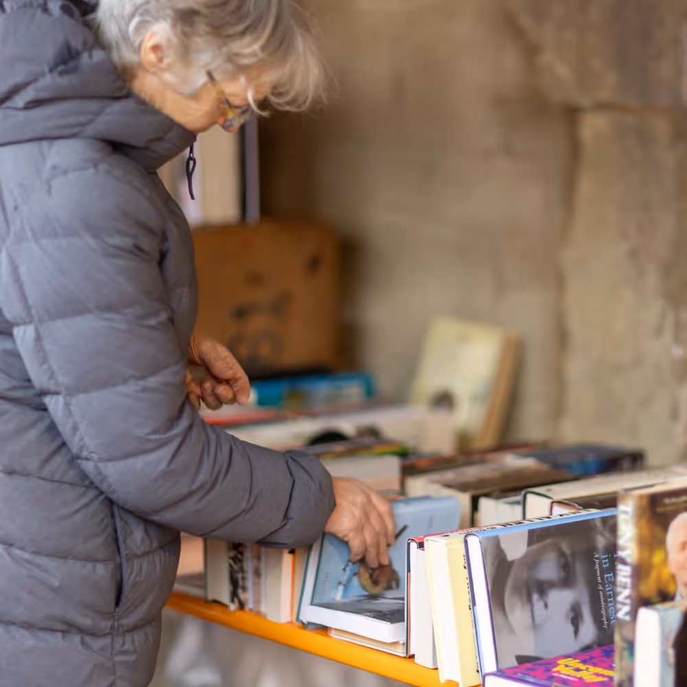 Lady browsing through second hand books on a market stall