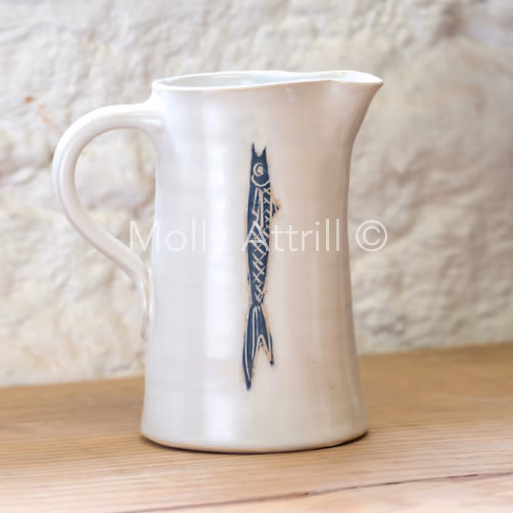 A white pottery jug with a fish design