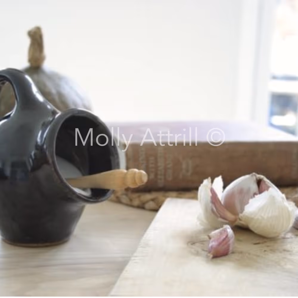 A salt pig and garlic on a chopping board