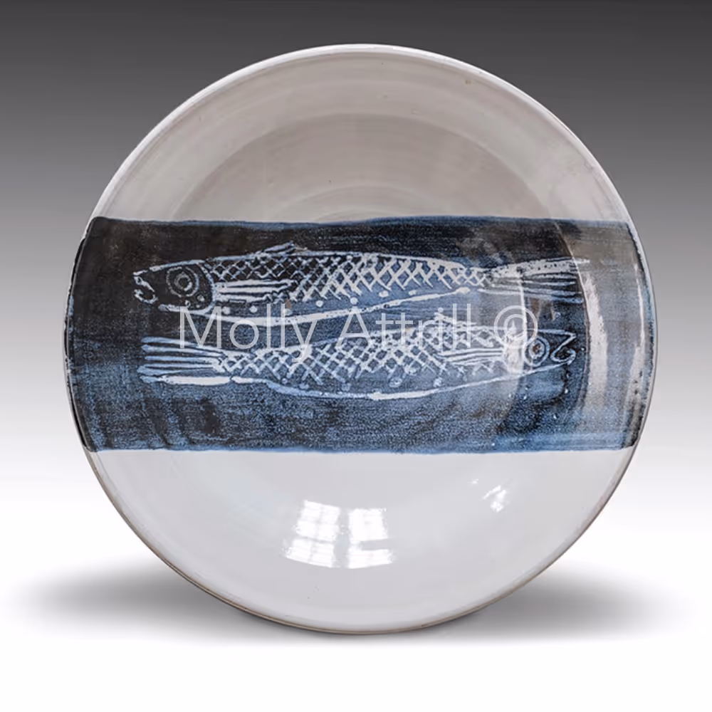 A blue and white bowl with a fish design
