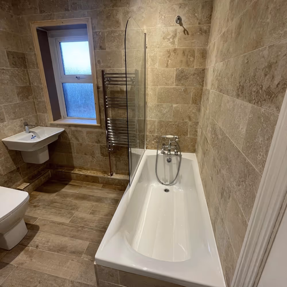 New bathroom with limestone tiled walls