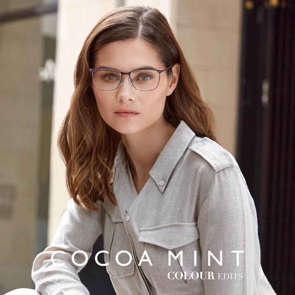 A lady in a grey suit, wearing brown spectacles