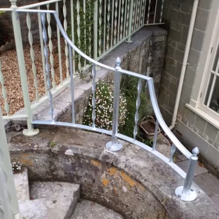 Metal railings curing around some stone steps
