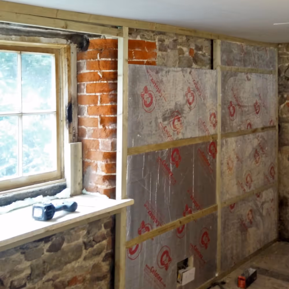 Insulating a wall before dry-lining