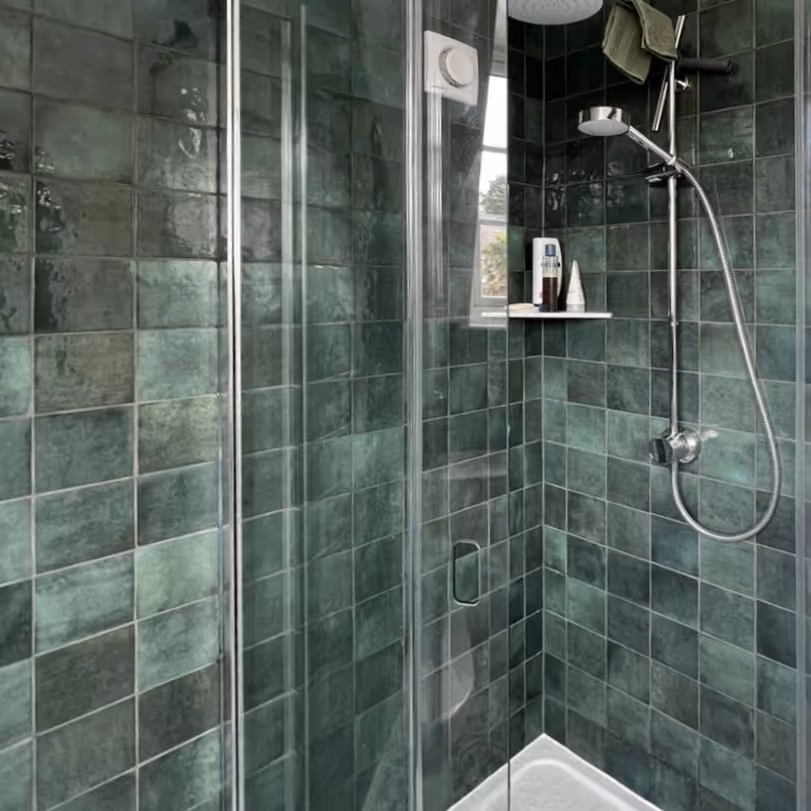 Shower cubicle with deep green tiles
