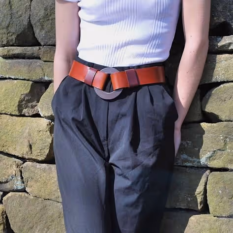 A lady wearing a leather belt with a ring buckle