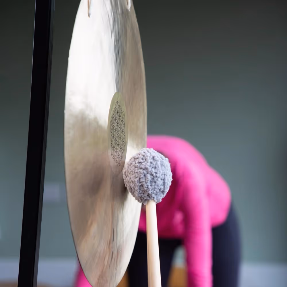A lady hitting a sound therapy gong