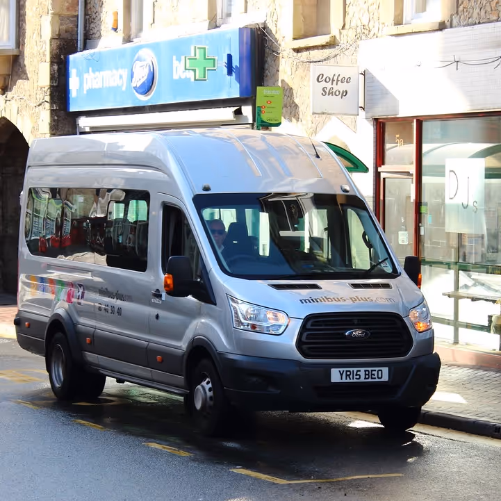A mini bus waiting at a bus stop