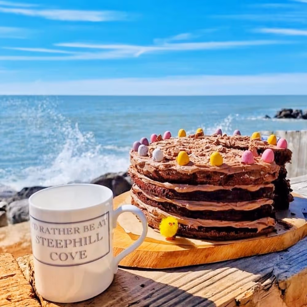 A whole chocolate cake on a table by the sea