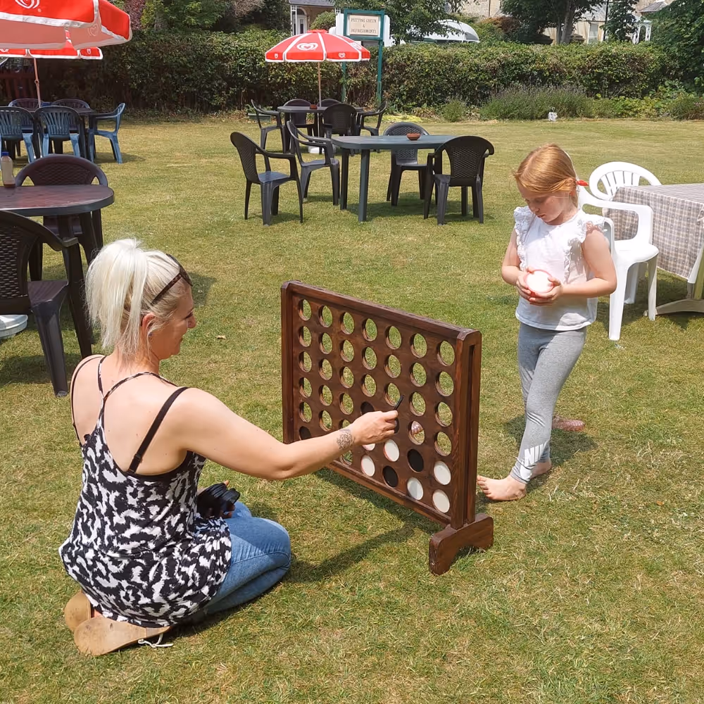 A mum and her daughter playing a giant Connect 4 game