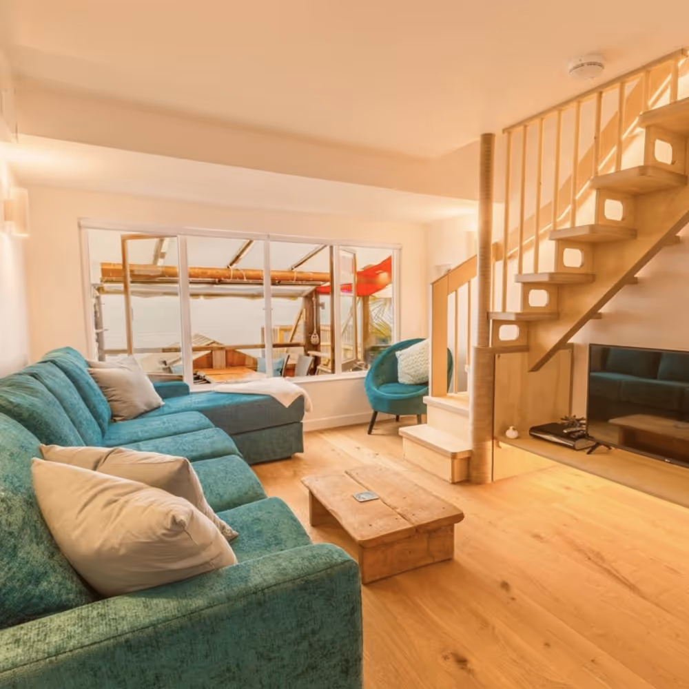 A living room with aqua sofas and pine furniture