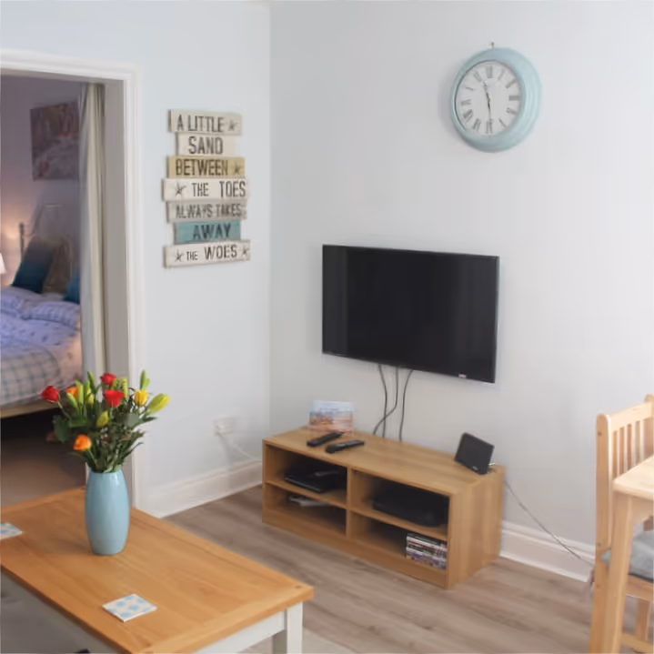 A living room with white walls and light oak furniture
