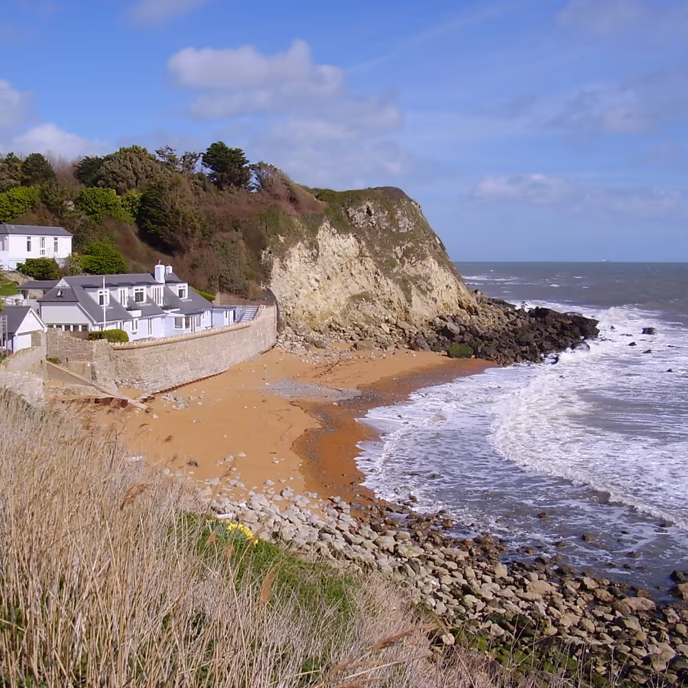 A large house built on a shingle beach