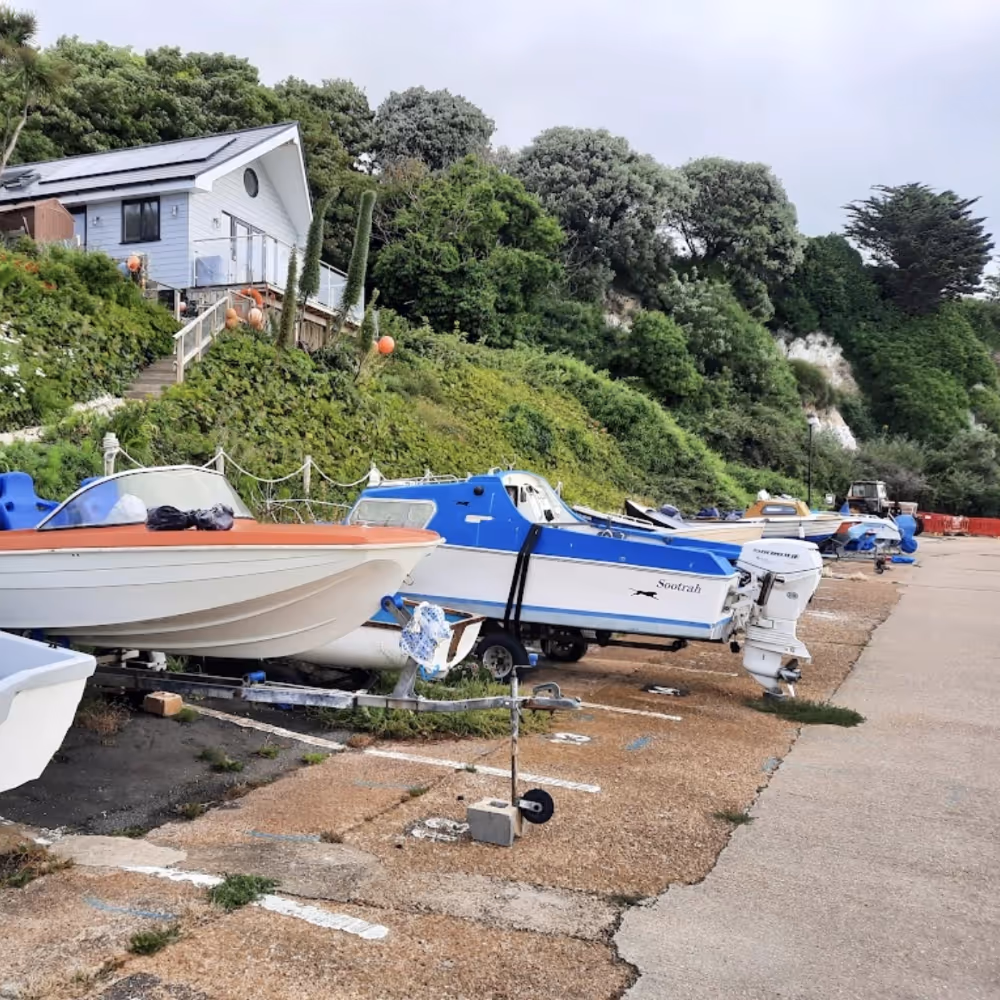Small sailing boats lined up on the shore