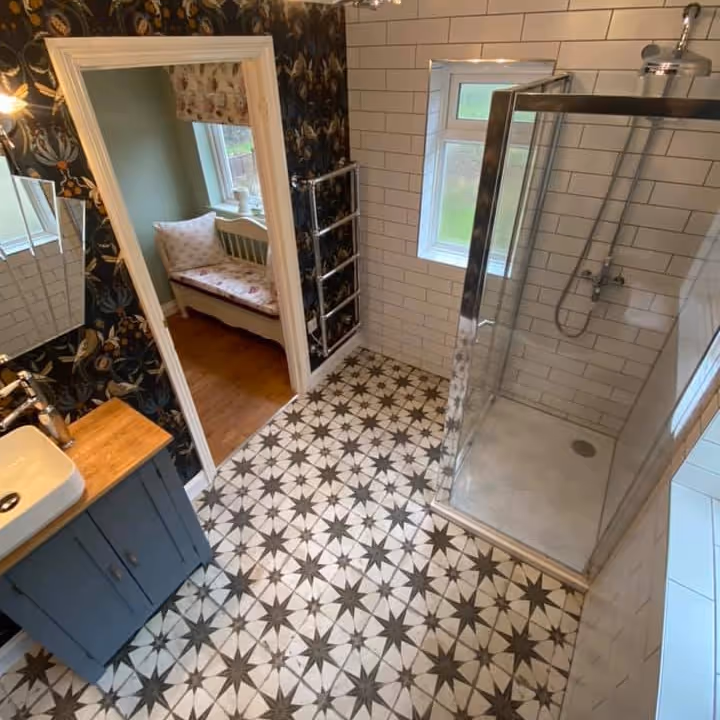 A shower room with a star patterned tiled floor