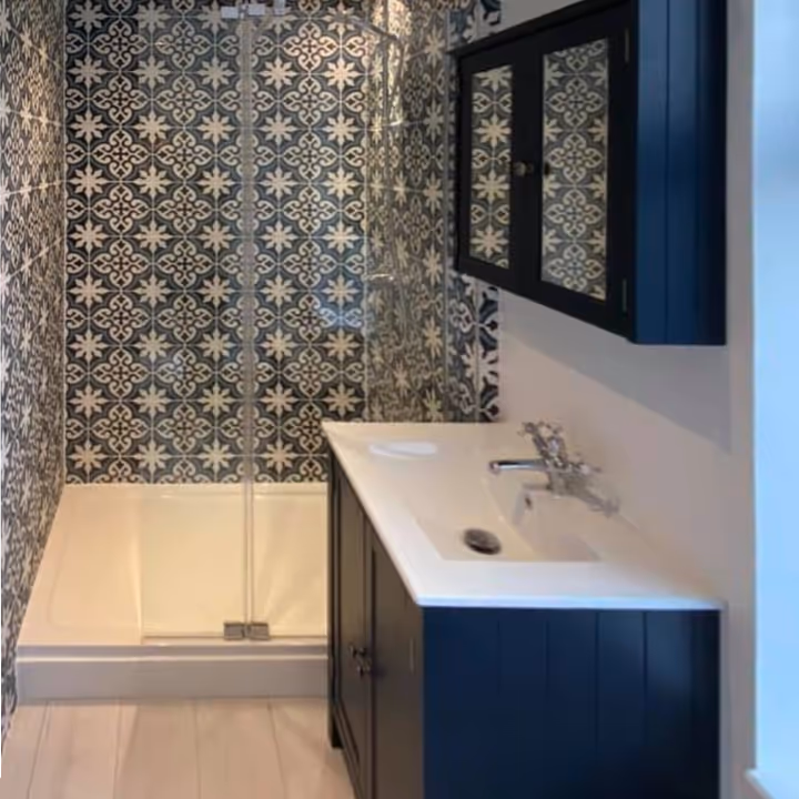 A shower room with navy blue cabinets
