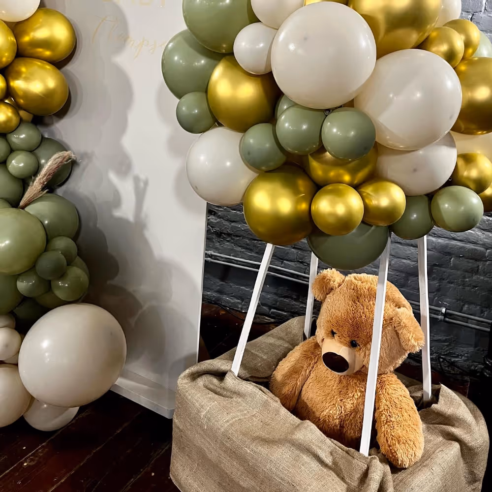 A big display of balloons and a big teddy in an air balloon basket