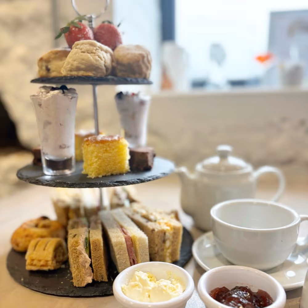 Afternoon tea with sandwiches, cake and a pot of tea