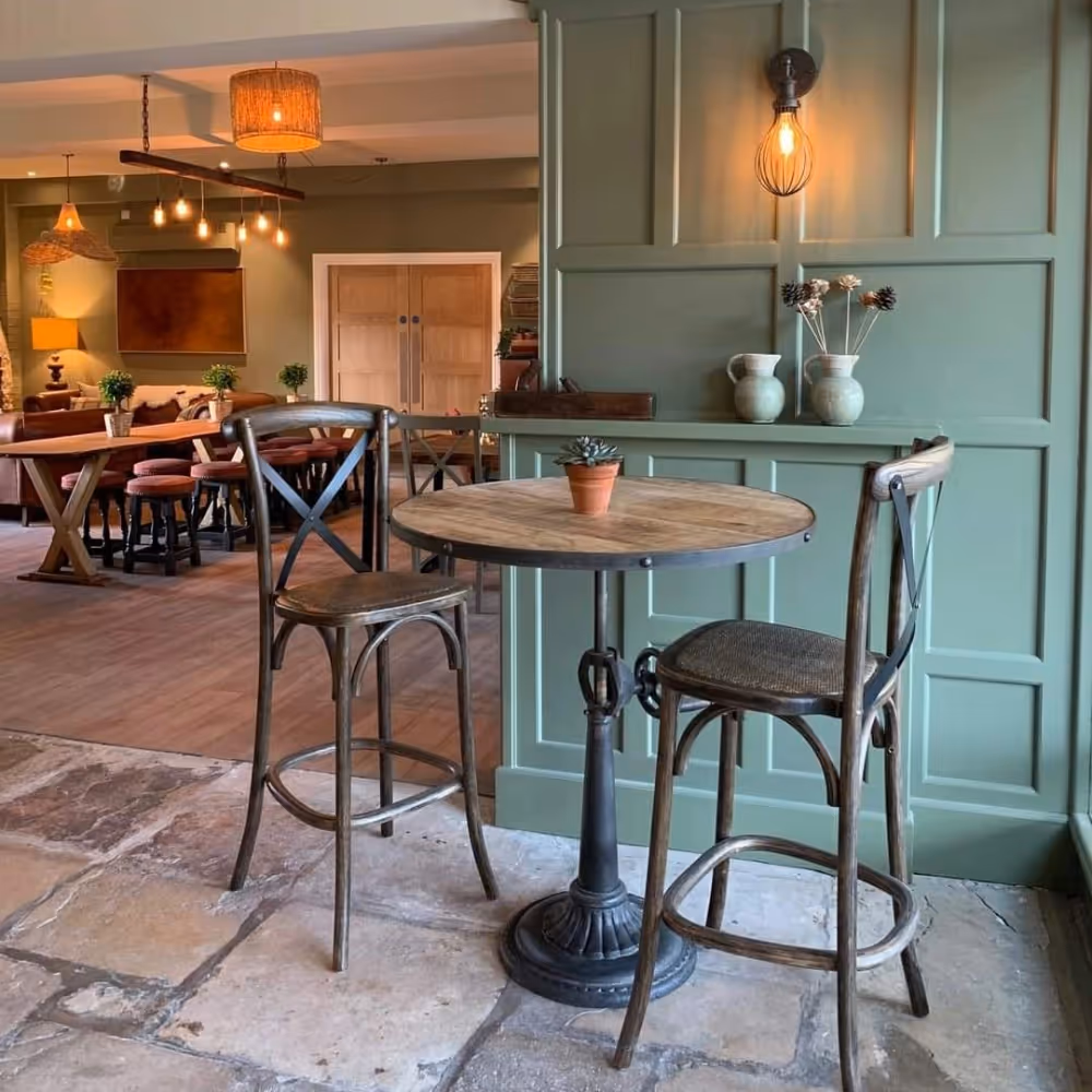 Bar table and stools in a pub, with low seating in the background