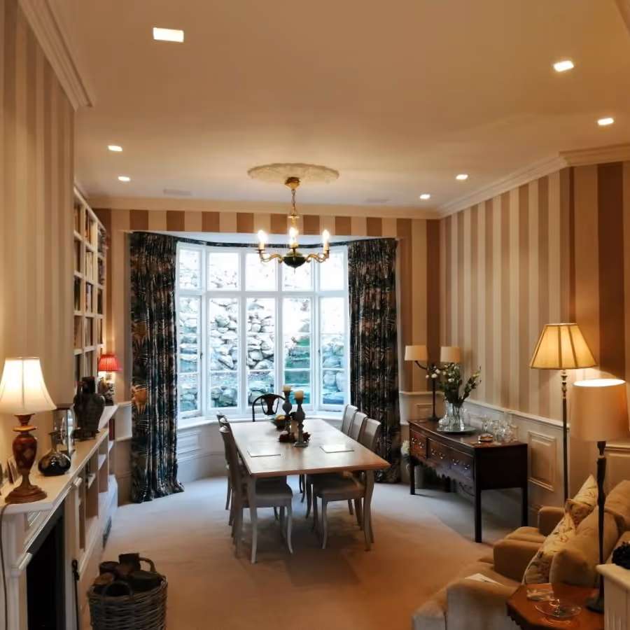 A living room with striped wallpaper and soft accent lighting