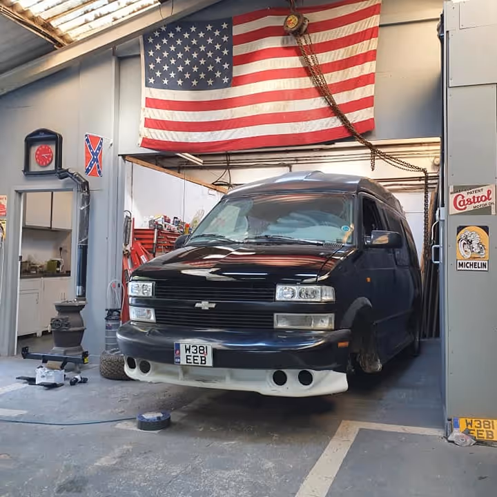 A black van being serviced in a garage