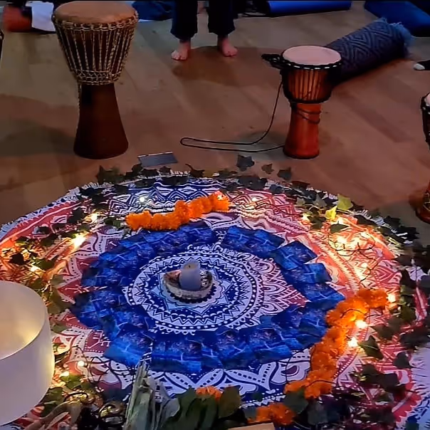Candles and African drums set up around a circular rug