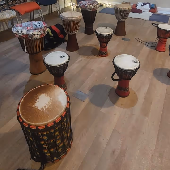 Various African drums, stood upon a wooden floor
