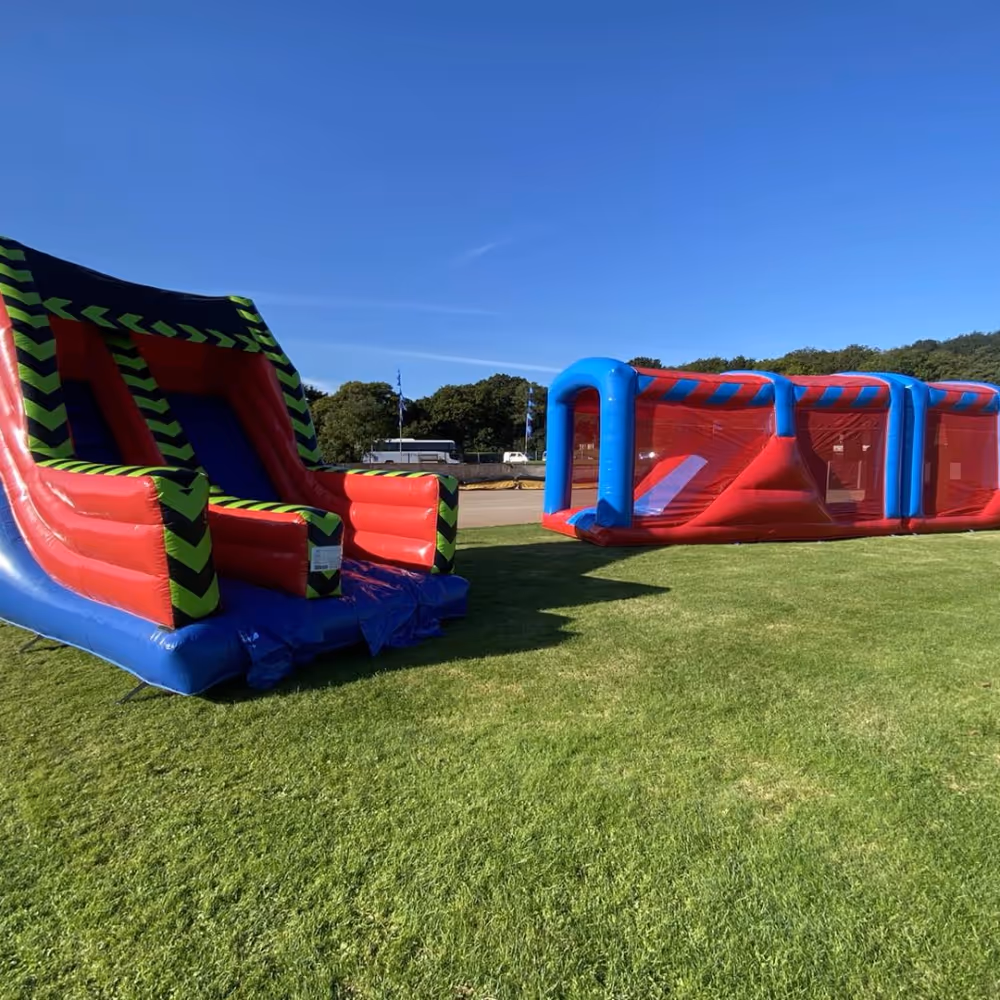 Two red and blue bouncy castles on grass