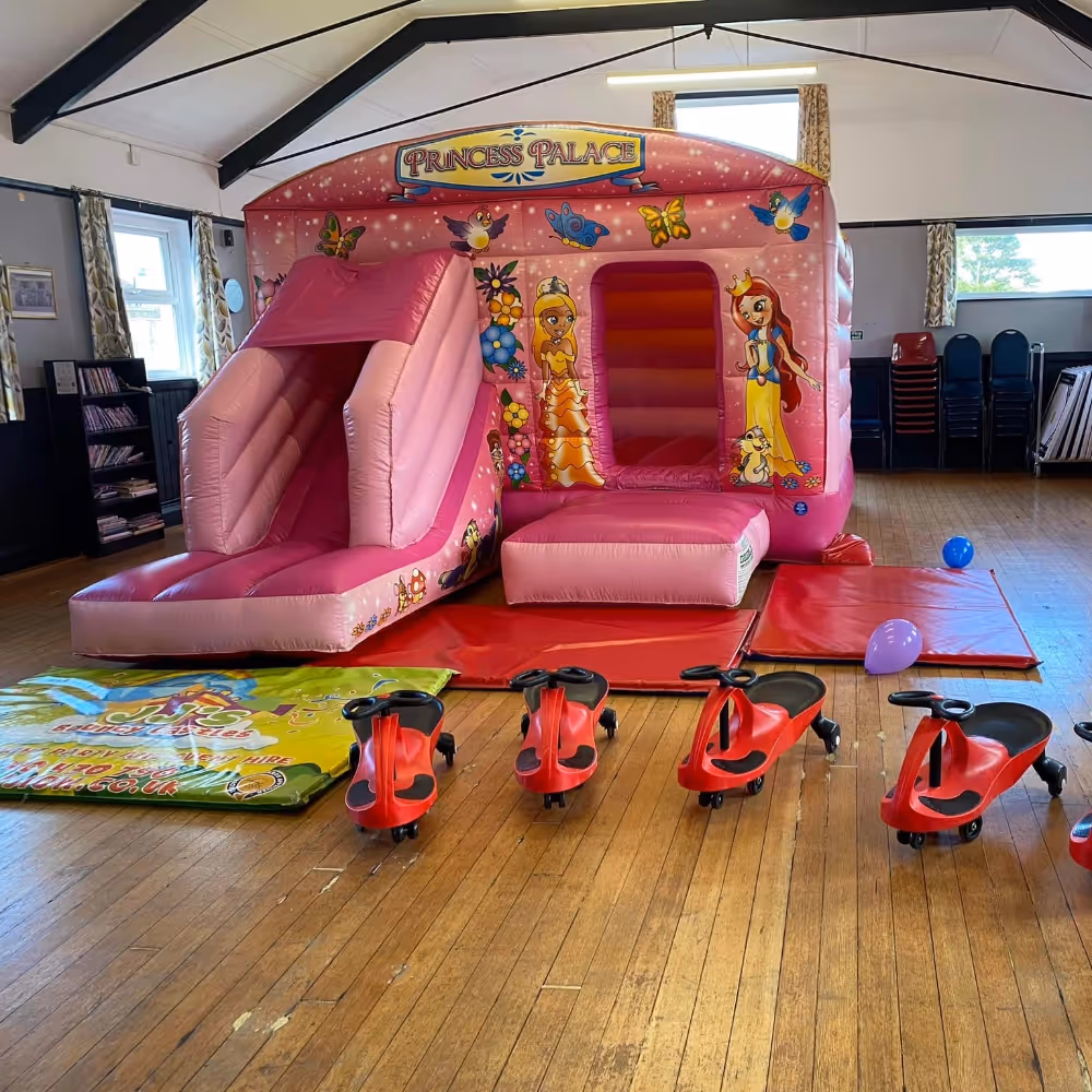 A pink bouncy castle inside a community hall