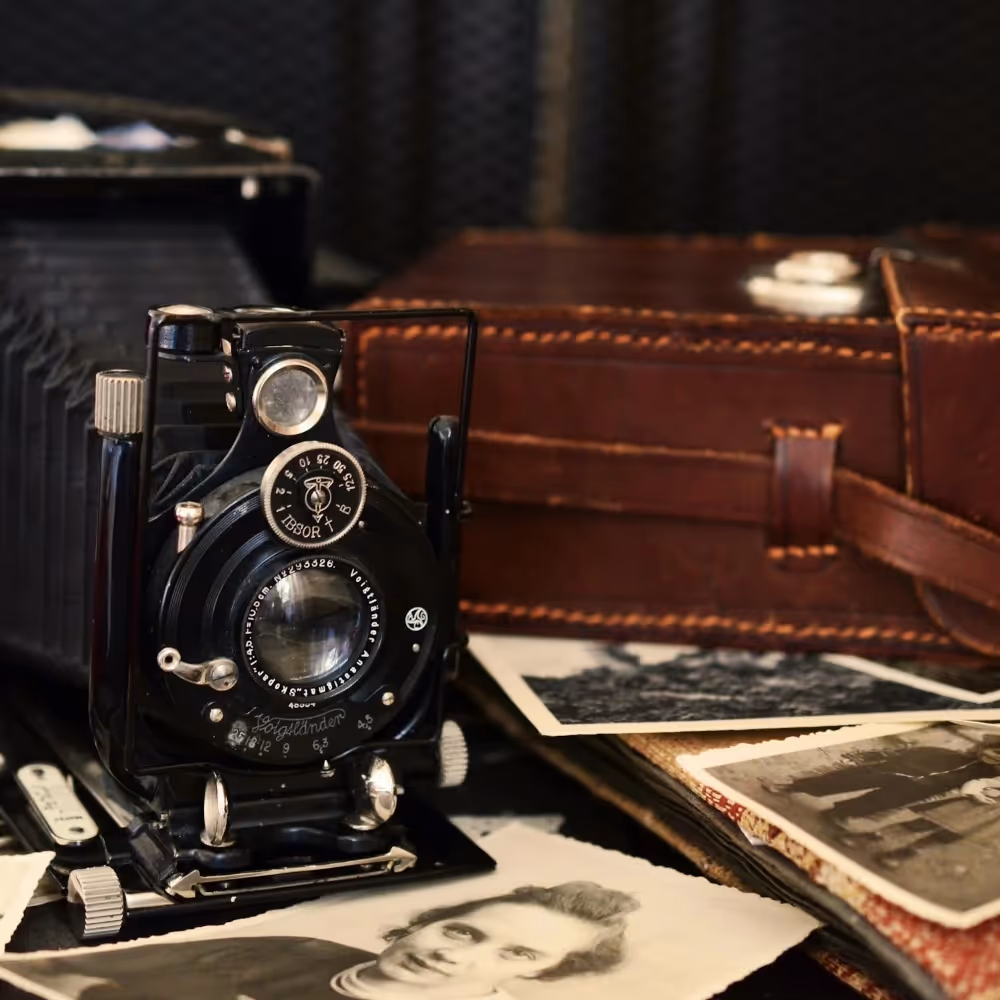 An antique camera and some sepia photographs