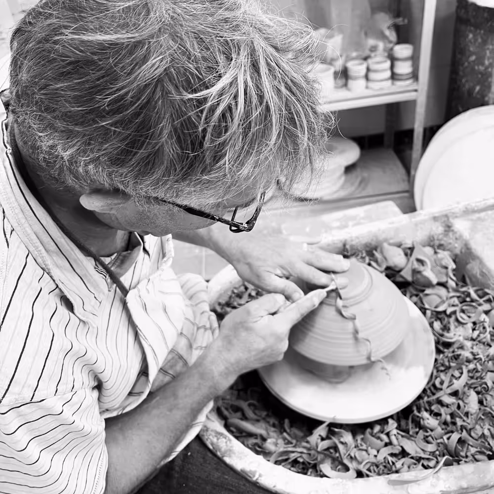 A potter trimming a leather hard bowl
