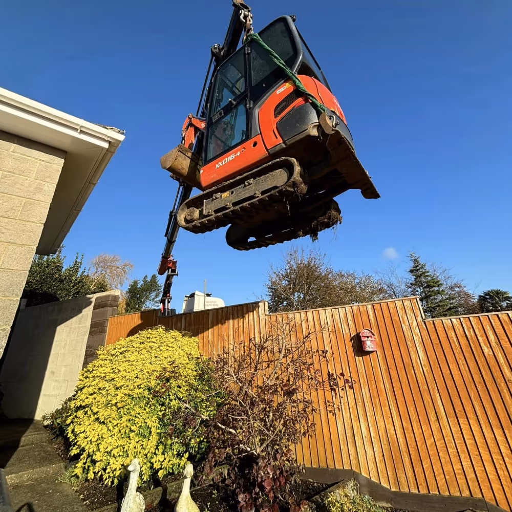 Heavy machinery being lifted into a garden