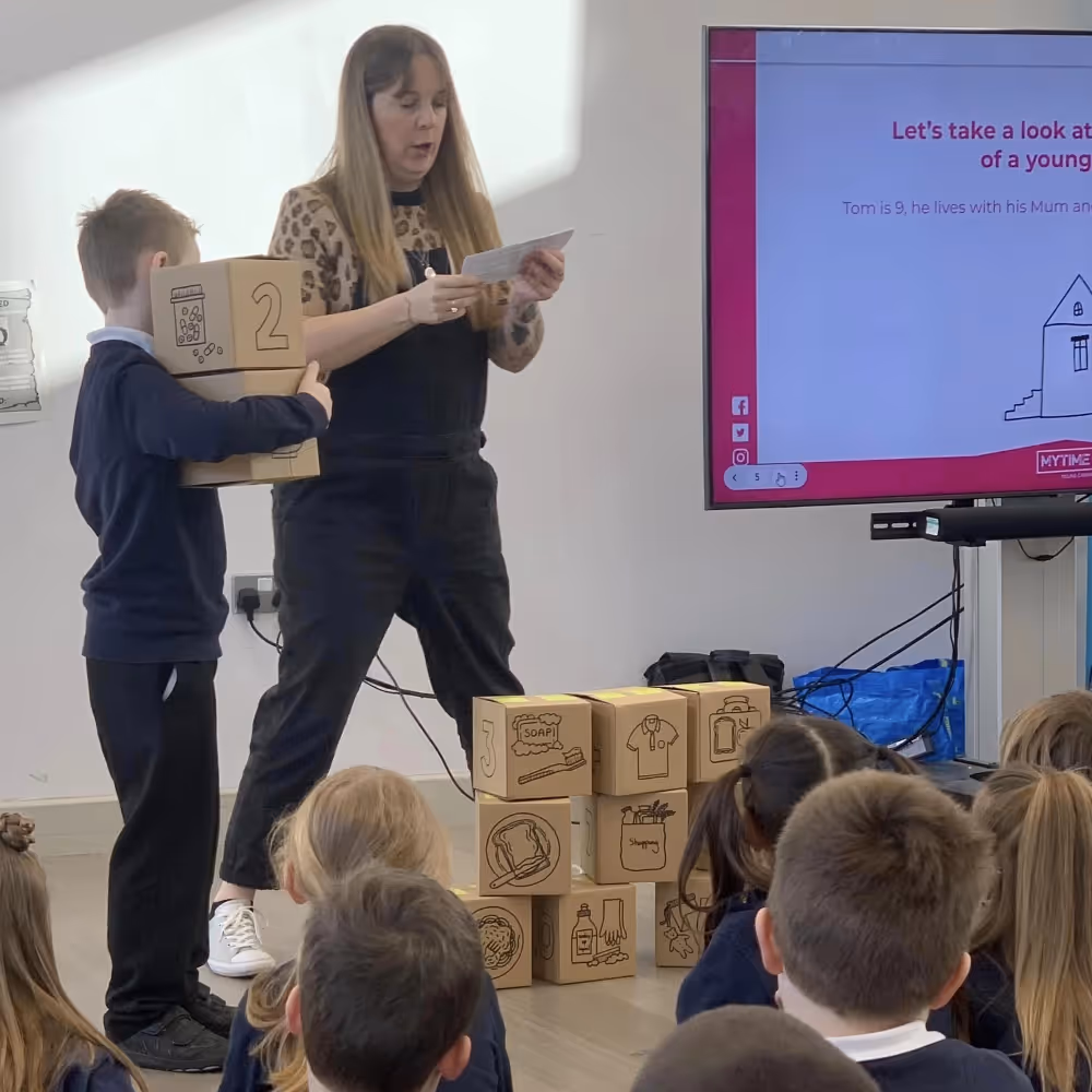 Teacher and pupil stood at the front of a class