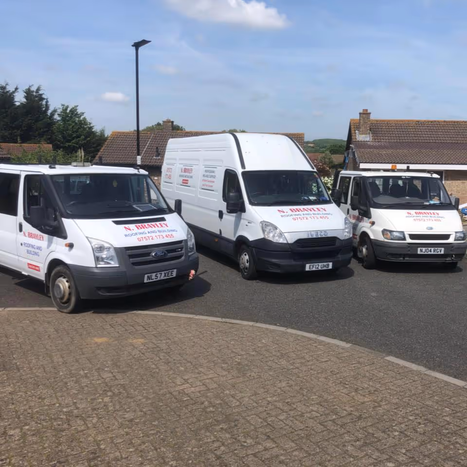 A row of 3 builders vehicles