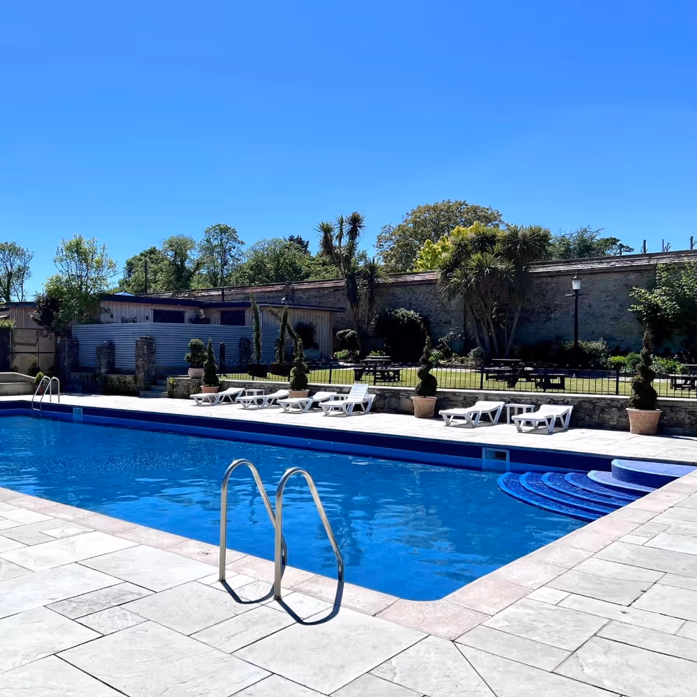 An outdoor swimming pool with sun loungers
